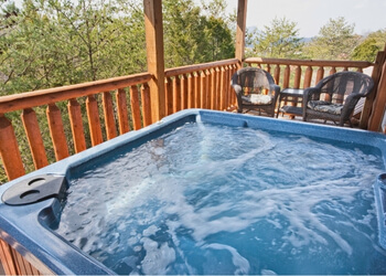 open hot tub sitting on a back porch overlooking the mountains0