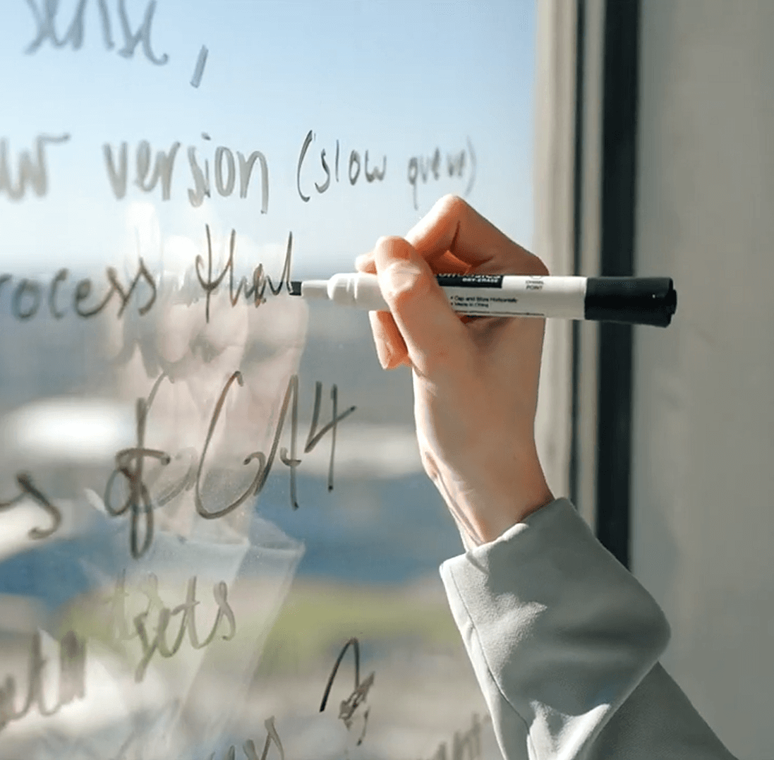 close up of hand writing with expo marker on a window
