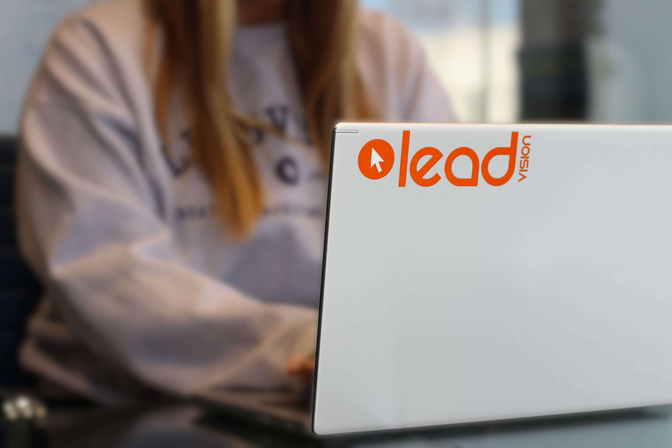 close up of a lead vision employee sitting in front of a computer screen, focused on the leadvision logo